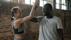 Happy sport couple giving high five after fitness workout at gym