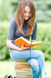 Happy Student Girl Sitting On Pile Of Books Stock Photography