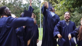 Happy students throwing mortar boards up
