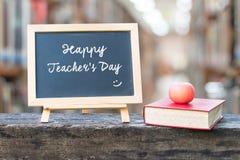 Happy teacher\'s day greeting announcement on black chalkboard on blur school college library background