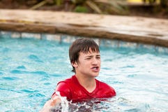 Happy teen boy in swimming pool with lips puckered. Handsome and silly teen boy with braces making mouth puckered in swimming pool Stock Images Happy teen boy in swimming pool with lips puckered. Handsome and silly teen boy with braces making mouth puckered in swimming pool Stock Images