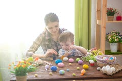 Happy time while painting easter eggs. Easter concept. Happy mother and her cute child getting ready for Easter by painting the eg royalty free stock photography Happy time while painting easter eggs. Easter concept. Happy mother and her cute child getting ready for Easter by painting the eg royalty free stock photography