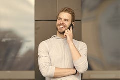 Happy to hear you. Man bearded walks with smartphone, urban background. Man pleasant smiling face speaks on smartphone stock photo Happy to hear you. Man bearded walks with smartphone, urban background. Man pleasant smiling face speaks on smartphone stock photo