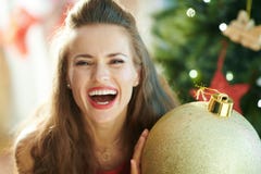 Happy woman with big gold Christmas ball near Christmas tree royalty free stock photography Happy woman with big gold Christmas ball near Christmas tree royalty free stock photography