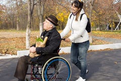 Happy Woman Helping A Disabled Elderly Man Royalty Free Stock Photography