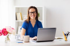Happy woman with laptop working at home or office