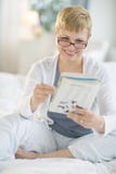 Happy Woman Reading Book On Bed stock photography Happy Woman Reading Book On Bed stock photography