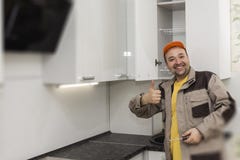 Happy Worker. Assembly Of Kitchen Furniture Royalty Free Stock Photos Happy Worker. Assembly Of Kitchen Furniture Royalty Free Stock Photos