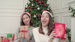 Happy young Asian women giving christmas gifts to each other in her living room at home in Christmas Festival. stock video Happy young Asian women giving christmas gifts to each other in her living room at home in Christmas Festival. stock video