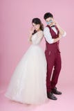 Happy young bride and groom wearing sunglasses on the pink background. Wedding couple, new family, wedding dress. Bridal wedding.