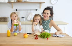Happy young brunette mother with cute little kids having breakfast royalty free stock photography Happy young brunette mother with cute little kids having breakfast royalty free stock photography