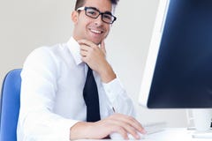 Happy young business man work in modern office on computer