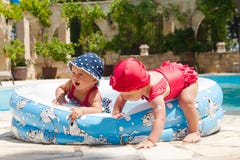 A happy young children is playing outside in a baby swimming pool Stock Image A happy young children is playing outside in a baby swimming pool Stock Image