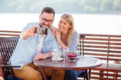 Happy young couple drinking coffee in a cafe, taking a selfie royalty free stock image Happy young couple drinking coffee in a cafe, taking a selfie royalty free stock image