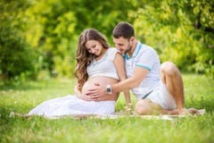 Happy young couple expecting baby, pregnant woman with husband touching belly royalty free stock image Happy young couple expecting baby, pregnant woman with husband touching belly royalty free stock image