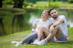 Happy young couple loving fitness in sportswear relaxing at park together in morning time. sport people sitting taking a break royalty free stock photos Happy young couple loving fitness in sportswear relaxing at park together in morning time. sport people sitting taking a break royalty free stock photos