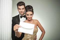 Happy Young Couple Presenting An Invite To Their Wedding Stock Images Happy Young Couple Presenting An Invite To Their Wedding Stock Images