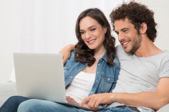 Happy Young Couple Using Laptop