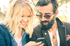 Happy young couple with vintage clothes having fun with phone stock photography Happy young couple with vintage clothes having fun with phone stock photography