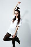 Happy young dark-haired girl with a funny hairstyle dressed in white t-shirt, black tights and shoes is posing on the royalty free stock photo Happy young dark-haired girl with a funny hairstyle dressed in white t-shirt, black tights and shoes is posing on the royalty free stock photo