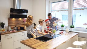 Happy young family cooking and having fun in the morning at kitchen stock photos Happy young family cooking and having fun in the morning at kitchen stock photos