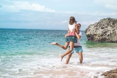 Happy Young Honeymoon Couple Having Fun On The Beach. Ocean, Tropical Vacation On Bali Island, Indonesia. Royalty Free Stock Image Happy Young Honeymoon Couple Having Fun On The Beach. Ocean, Tropical Vacation On Bali Island, Indonesia. Royalty Free Stock Image