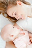 Happy Young Mother And Her Baby Lying In Bed Royalty Free Stock Images