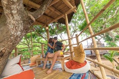 Happy Young Romantic Caucasian Couple In Gazebo On The Tree, Tropical Bali Island, Indonesia.. Vacation Honeymoon Stock Photo Happy Young Romantic Caucasian Couple In Gazebo On The Tree, Tropical Bali Island, Indonesia.. Vacation Honeymoon Stock Photo