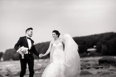 Happy young wedding couple having fun on the beach. Black and white royalty free stock images Happy young wedding couple having fun on the beach. Black and white royalty free stock images