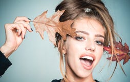 Happy Young Woman Are Preparing For Autumn Sale Day. Surprise Woman Playing With Leaf And Looking At Camera. Beautiful Stock Photo Happy Young Woman Are Preparing For Autumn Sale Day. Surprise Woman Playing With Leaf And Looking At Camera. Beautiful Stock Photo