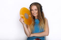 Happy young woman in big black professional dj headphones holding trendy yellow colorful vinyl record posing against white studio Stock Image Happy young woman in big black professional dj headphones holding trendy yellow colorful vinyl record posing against white studio Stock Image
