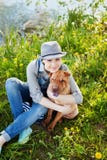 Happy young woman in denim overalls and hat hugging his beloved dog Shar Pei in the green grass in sunny day, true friends forever. People pets concept Stock Photos Happy young woman in denim overalls and hat hugging his beloved dog Shar Pei in the green grass in sunny day, true friends forever. People pets concept Stock Photos