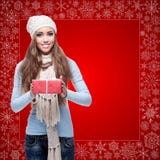 Happy young woman holding gift over winter background Royalty Free Stock Image Happy young woman holding gift over winter background Royalty Free Stock Image