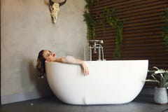Happy young woman relaxing in bathtub stock image Happy young woman relaxing in bathtub stock image