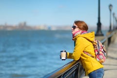 Happy young woman tourist sightseeing in New York City at sunny spring day. Female traveler drinking coffee in downtown Manhattan. royalty free stock image Happy young woman tourist sightseeing in New York City at sunny spring day. Female traveler drinking coffee in downtown Manhattan. royalty free stock image