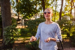 Happy young woman walking in summer park. Girl wearing stylish clothes and accessories stock images Happy young woman walking in summer park. Girl wearing stylish clothes and accessories stock images