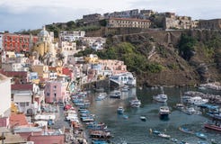 The harbour at Corricella fishing village with pastel coloured houses on the island of Procida Italy, photographed from the cliff. stock photo The harbour at Corricella fishing village with pastel coloured houses on the island of Procida Italy, photographed from the cliff. stock photo