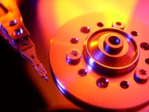 Hard Drive. A macro shot of the inside of a computer's hard drive with the platter mount and read/write head. Colored light for an interesting background Hard Drive. A macro shot of the inside of a computer's hard drive with the platter mount and read/write head. Colored light for an interesting background