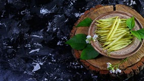 Haricots jaunes d'asperge d'un plat d'argile, sur le tronçon en bois, fond foncé Recette de nourriture sur le fond en bois Vue de images stock Haricots jaunes d'asperge d'un plat d'argile, sur le tronçon en bois, fond foncé Recette de nourriture sur le fond en bois Vue de images stock