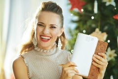 Hausfrau nahe Weihnachtsbaum-Vertretungstagebuch auf Seite am 25. Dezember stockfoto Hausfrau nahe Weihnachtsbaum-Vertretungstagebuch auf Seite am 25. Dezember stockfoto