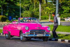 HAVANA, CUBA-OCT 25- Tourist enjoys a photo op in an antique cars used as taxis in Havana, on October 25, 2015 stock photo HAVANA, CUBA-OCT 25- Tourist enjoys a photo op in an antique cars used as taxis in Havana, on October 25, 2015 stock photo