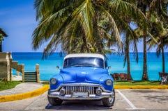 HDR -美国蓝色经典汽车停放在海滩的棕榈下在巴拉德罗角古巴- Serie古巴报告文学 免版税图库摄影 HDR -美国蓝色经典汽车停放在海滩的棕榈下在巴拉德罗角古巴- Serie古巴报告文学 免版税图库摄影