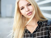 Headshot of young beautiful excited woman with gorgeous natural lips, blue and brown eyes in black blouse on urban metal strips ba Stock Photos Headshot of young beautiful excited woman with gorgeous natural lips, blue and brown eyes in black blouse on urban metal strips ba Stock Photos