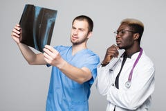 Healthcare, medical and radiology concept - two doctors looking at x-ray on gray background royalty free stock images Healthcare, medical and radiology concept - two doctors looking at x-ray on gray background royalty free stock images