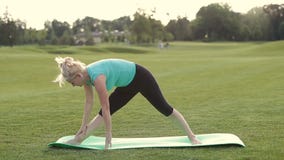 Healthy adult woman doing yoga exercises outdoors