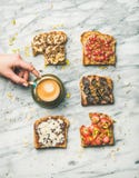 Healthy breakfast with wholegrain toasts and woman`s hand taking coffee Stock Photography Healthy breakfast with wholegrain toasts and woman`s hand taking coffee Stock Photography