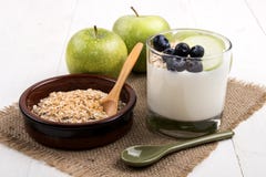 healthy breakfast with yogurt in a glass, fresh green apples, juicy blueberries and toasted oats royalty free stock photography healthy breakfast with yogurt in a glass, fresh green apples, juicy blueberries and toasted oats royalty free stock photography