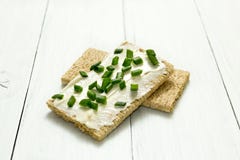 Healthy crunchy rye bread with soft cheese and green onion on a white wooden table stock photos Healthy crunchy rye bread with soft cheese and green onion on a white wooden table stock photos
