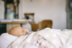 Healthy daytime sleep for the newborn. A baby in a baby cocoon sleeps in a room royalty free stock photography Healthy daytime sleep for the newborn. A baby in a baby cocoon sleeps in a room royalty free stock photography