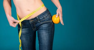 Healthy female body with orange and measuring tape. Healthy fitness and eating lifestyle concept. Royalty Free Stock Photography Healthy female body with orange and measuring tape. Healthy fitness and eating lifestyle concept. Royalty Free Stock Photography